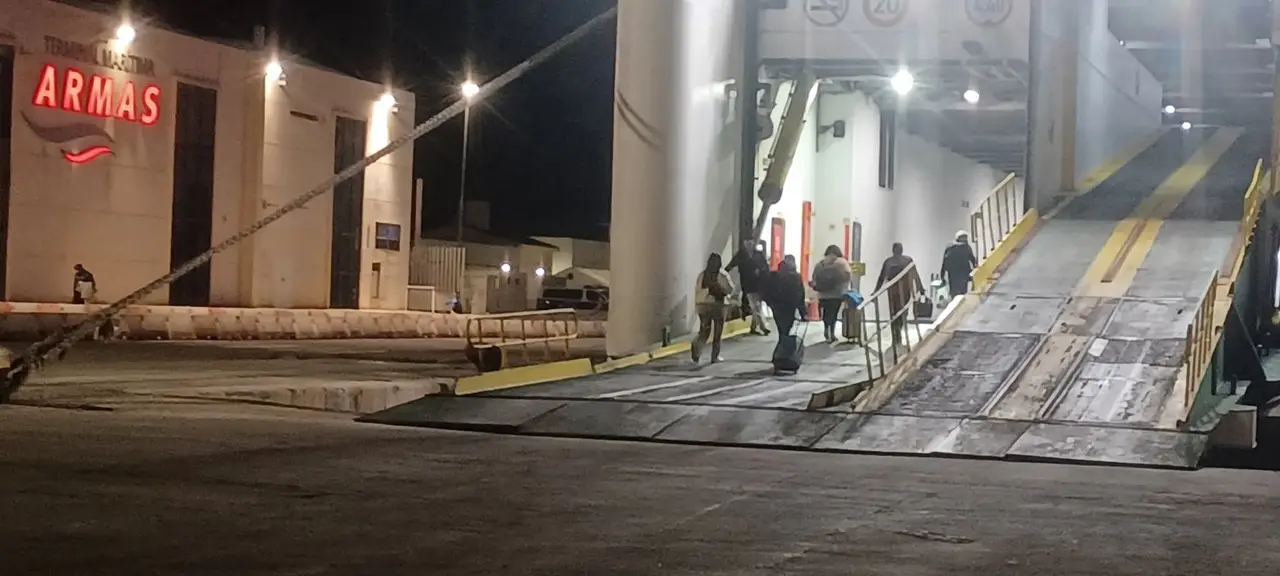 Pasajeros embarcando por la rampa de carga del buque ante la ausencia de pasarelas peatonales en el puerto