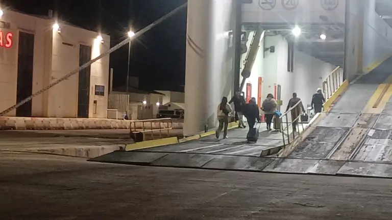 Pasajeros embarcando por la rampa de carga del buque ante la ausencia de pasarelas peatonales en el puerto